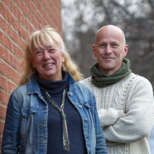 Ingrid Thorold och Mats Persson stående utomhus vid en vägg. Foto.